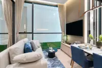 1 Bedroom Condo for Sale at Once Wong Amat: Living room with a sofa, large window, TV, and dining table with blue chairs.