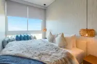 2 Bedroom Condo for Sale at Veranda Residence Pattaya bedroom with furry throw and large window.