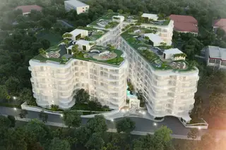 The Coral Pattaya, aerial view of the complex with green rooftops, pools, and surrounding trees.