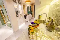Studio Condo for Sale at Seven Seas Le Carnival: Bedroom with large bed, golden headboard, and elegant gold curtains.