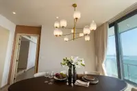 3 Bedroom Condo for Sale at Arom Wongamat dining area with white floral centerpiece and coastal skyline view