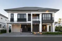 4 Bedroom House for Sale at Chieftain modern two-storey exterior with dark roof, dual balconies, carport, and landscaped entrance at dusk