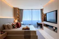 2 Bedroom Condo for Sale at Sea Sky By Sand master bedroom with king bed, floor-to-ceiling sheer curtains, and built-in shelving