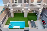 10 Bedroom House for Sale in Bang Lamung aerial view of courtyard pool, artificial turf, outdoor seating, and multi-storey facade with string lights