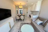 1 Bedroom Condo for Rent at Copacabana Beach Jomtien open-plan living room with gold chandelier, dining table, and fitted kitchen