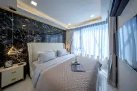 1 Bedroom Condo for Sale at Grand Solaire Noble master bedroom with white upholstered bed and floor-to-ceiling sheer curtains