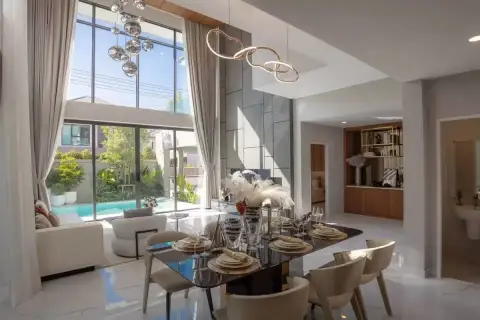5 Bedroom House for Sale at The Lake Huay Yai open-plan dining area with dark glass table, ring pendant light, and pool view beyond