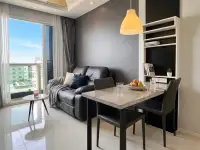 1 Bedroom Condo for Sale at MaxxCity Condo living area with leather sofa, dining table, and city view window