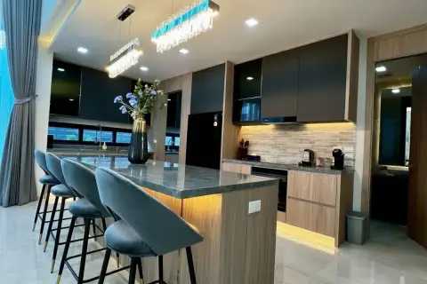 5 Bedroom House for Sale at Impress House Village modern kitchen with marble island, bar stools, and crystal chandelier