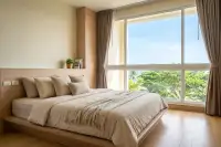 2 Bedroom Condo for Sale at Cetus Beachfront second bedroom with king bed, wood headboard and large window with garden view