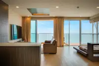 2 Bedroom Condo for Sale at Cetus Beachfront living room with leather sofa, flat-screen TV, and floor-to-ceiling sea view windows
