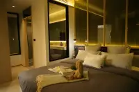2 Bedroom Condo for Sale at SKYPARK Lucean Jomtien Pattaya master bedroom at night with plush pillows and view into ensuite bathroom