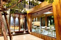 10 Bedroom House for Sale in Na Chom Thian: Exterior of the 'Greyduck Lobby' entrance and adjacent cafe area at night.