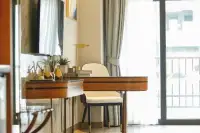 Studio Condo for Sale at Wyndham Jomtien Pattaya: elegant desk area with a chair, lamp, and balcony door with curtains.
