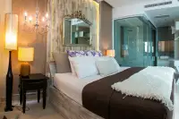 1 Bedroom Condo for Sale at Cetus Beachfront master bedroom with double bed, ornate mirror, chandelier and en-suite glass shower
