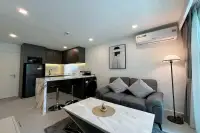 1 Bedroom Condo for Sale at City Center Residence open-plan living area with dark kitchen marble island and grey sofa