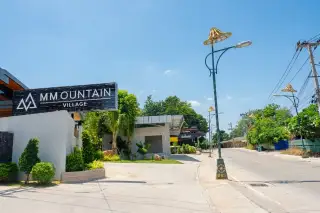 M Mountain Village entrance sign with landscaped garden and street view in Pattaya Thailand