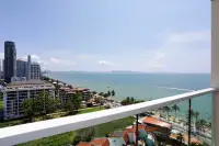 1 Bedroom Condo for Sale at Cetus Beachfront high-floor balcony overlooking Pattaya Bay coastline and city skyline on sunny day