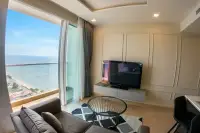 1 Bedroom Condo for Sale at Cetus Beachfront living room with sofa, flat-screen TV, and floor-to-ceiling sea view window