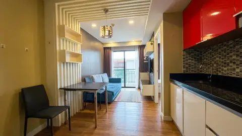 1 Bedroom Condo for Sale at Dusit Grand Park 1 living room with blue sofa, dining table and kitchen counter