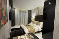 Studio Condo for Sale at Grand Solaire Noble studio room with double bed, gold bedding, marble feature wall, and dining area