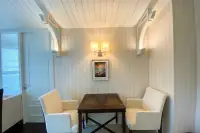 1 Bedroom Condo for Rent at Grand Florida Beachfront Condo Resort Pattaya dining area with dark wood table white chairs and wall sconce lighting