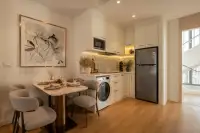 1 Bedroom Condo for Sale at Seaspire Jomtien dining area with marble table, grey chairs, white kitchen, stainless steel fridge and wood floors