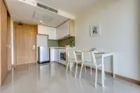 1 Bedroom Condo for Sale at The Riviera Jomtien compact kitchen and dining area with light wood doors.
