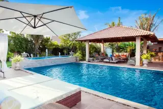 Sedona Villas 1 luxurious outdoor swimming pool with sun loungers, patio umbrella, and covered lounge area with seating.