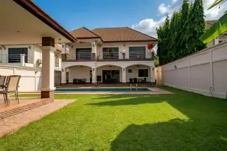 Lakeside Court front exterior with a red patterned driveway, covered entrance, and lush green landscaping.