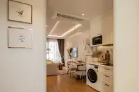 1 Bedroom Condo for Sale at Seaspire Jomtien open-plan living area with white kitchen cabinets, marble backsplash, and washer unit