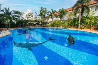 View Talay Residence 1&2 large outdoor swimming pool with dolphin mosaic tile design and tropical landscaping