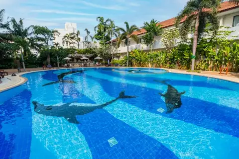 View Talay Residence 1&2 large outdoor swimming pool with dolphin mosaic tile design and tropical landscaping