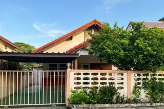 Sangchai Villa exterior with a red tiled roof, carport, and a patterned white fence with a green gate in Pattaya, Thailand.