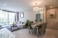 2 Bedroom Condo for Sale at Copacabana Coral Reef elegant dining area with mirrored wall, crystal chandelier, and garden balcony view
