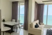 2 Bedroom Condo for Sale at Del Mare open-plan living and dining area with white dining set and sweeping sea views