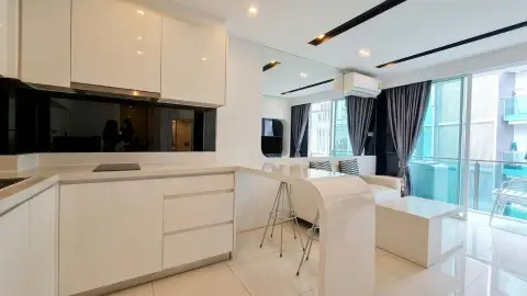 1 Bedroom Condo for Sale at City Center Residence kitchen counter with bar stools and balcony view through sheer curtains