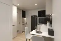 2 Bedroom Condo for Sale at The Indeed Condo Pattaya compact kitchen with black Samsung fridge, wood cabinets, and dining table