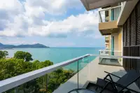 1 Bedroom Condo for Sale at Del Mare private balcony with glass railing, lounge chairs, and panoramic turquoise sea and mountain views