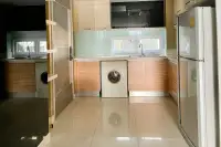3 Bedroom Condo for Sale at Apus kitchen with wood lower cabinets, cream upper cabinets, washing machine, and large refrigerator