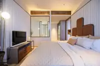 2 Bedroom Condo for Sale at Arom Jomtien master bedroom with leather headboard, TV unit and glass-walled ensuite
