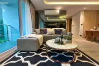 2 Bedroom Condo for Sale at Pristine Park 3 living room with grey sectional sofa, marble coffee table, and large glass balcony doors at night