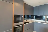 3 Bedroom Condo for Rent at Cosy Beach View modern kitchen with grey matte cabinets, built-in oven, microwave and mirror splashback