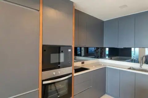 3 Bedroom Condo for Rent at Cosy Beach View modern kitchen with grey matte cabinets, built-in oven, microwave and mirror splashback