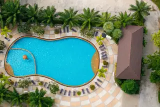 View Talay 7 aerial view of kidney-shaped pool with sunbathers and tropical landscaping