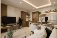 1 Bedroom Condo for Sale at Siam Oriental Beach: Living room with TV, dining area, and kitchen with washing machine.