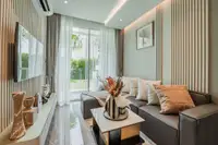 1 Bedroom Condo for Sale at The Coral Pattaya combined living room and bedroom with modern furnishings and balcony view.