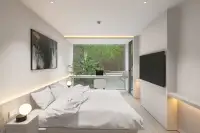 1 Bedroom Condo for Sale at Celine Wongamat minimalist bedroom with LED cove lighting, desk workspace, and tropical garden view