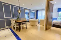 2 Bedroom Condo for Sale at Seven Seas Cote d'Azur: dining area with blue accent wall, living room, and open bedroom door.
