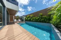 5 Bedroom House for Sale in Bang Lamung private swimming pool with wood deck, sun loungers and tropical garden landscaping